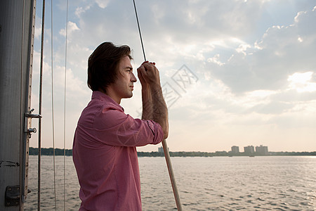 游艇上的中年男子，看风景图片