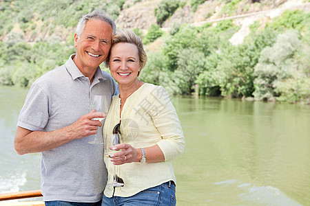 在船上度假时带着酒杯的老年夫妇图片