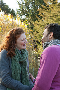 一对幸福的情侣面对面站在德威治公园图片