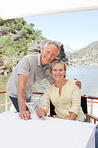在船上度假时带着酒杯的老年夫妇图片