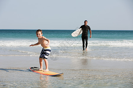 小男孩在浅水中冲浪图片