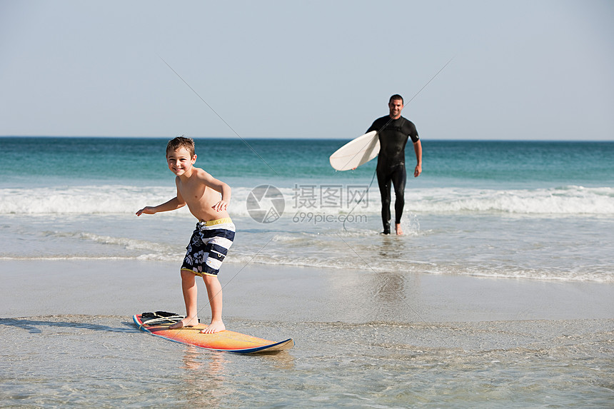 小男孩在浅水中冲浪图片