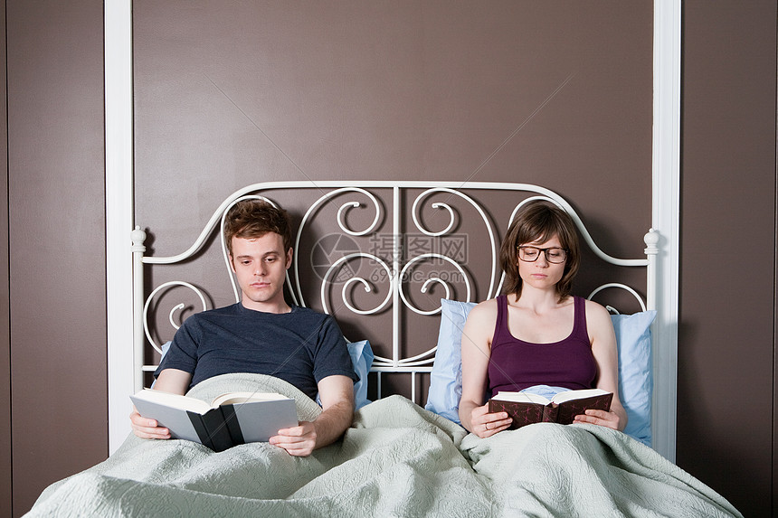 年轻夫妇在床上看书图片
