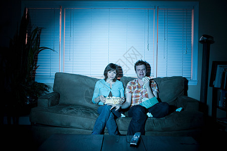 年轻夫妇在看电视，男人在哭图片
