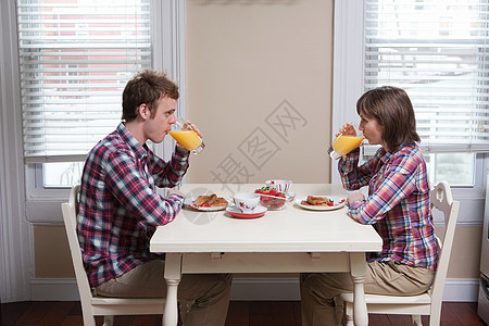 年轻夫妇在餐桌上喝橙汁图片