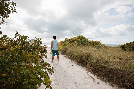 风筝冲浪者步行去海滩图片