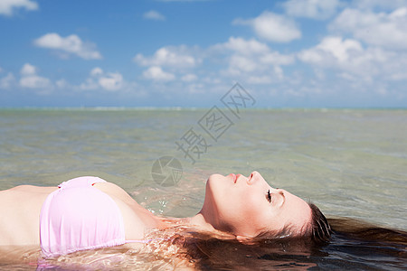漂浮在海上的年轻女子图片