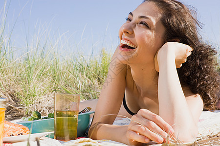 在野餐毯上笑的女人高清图片
