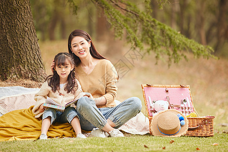 温馨母女坐在树下读书图片