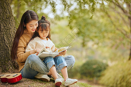 户外背景温馨母女坐在树下读书背景