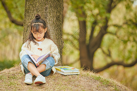 一个小女孩小女孩户外看童话书背景