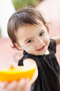 女婴举着橘子特写图片