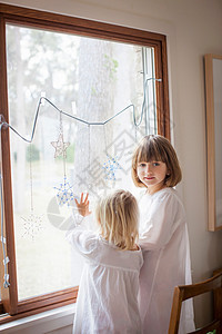 孩子们欣赏玻璃窗上的装饰性雪花图片