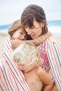 拥抱自然母亲和女儿裹着条纹毛巾背景