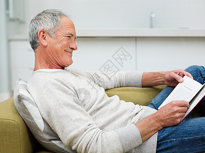 坐在沙发上看书的老人图片