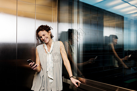 电梯里的女人看着手机图片