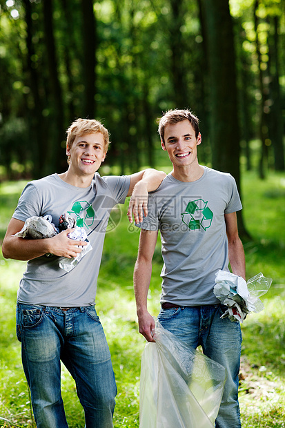 两个年轻人在树林里捡垃圾图片