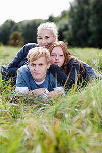 三个年轻人躺在草地上图片
