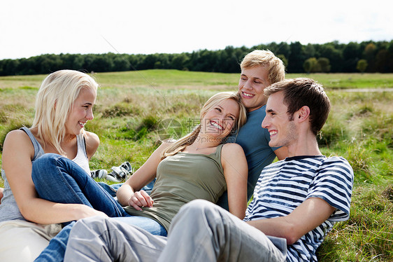 四个年轻人坐在草地上图片