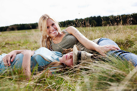 两个年轻女人躺在草地上图片