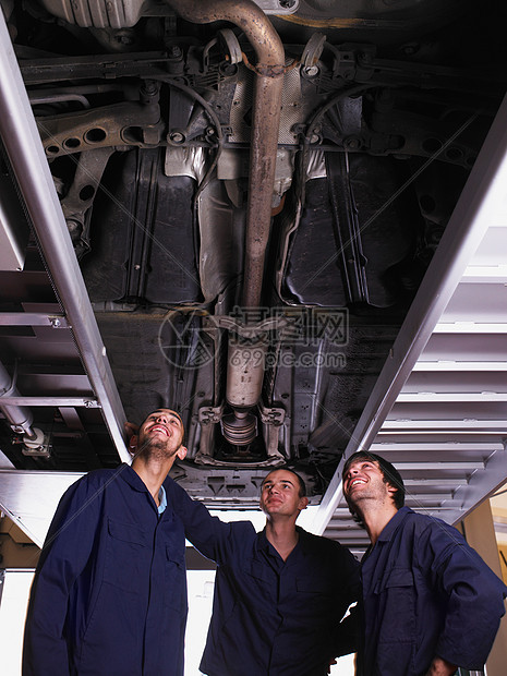 三个机修工站在车下图片