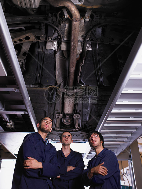 三个机修工站在车下图片
