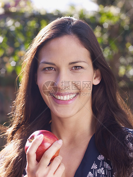 拿着苹果微笑的年轻女子图片