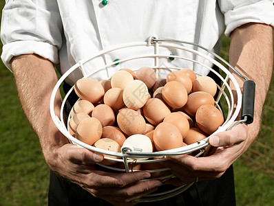 厨师拿着装满鸡蛋的篮子背景图片