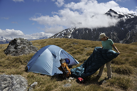 帐篷野营新西兰山区的中年妇女野营背景