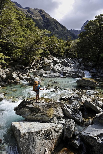 站在新西兰河流岩石上的女人图片