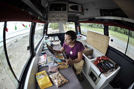 在露营车上组织食物的中年妇女图片