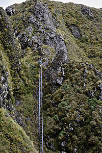 新西兰山脊，女徒步者爬山梯的远视图图片