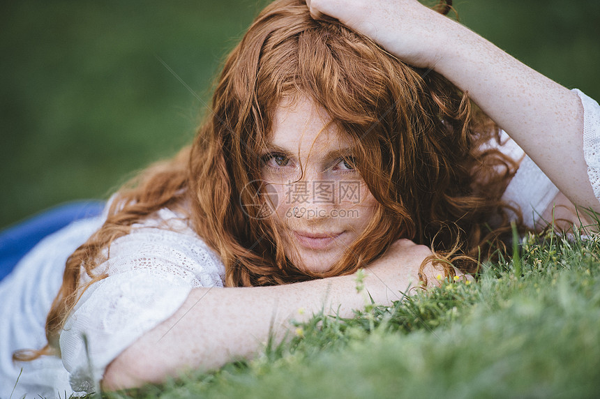 躺在草地上的年轻女子图片