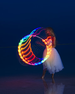 穿着派对礼服的女人在黄昏时用彩灯箍着图片