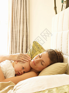 母亲抱着婴儿在床上图片