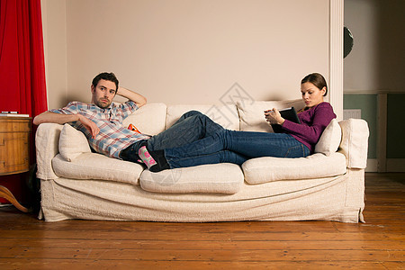 坐在沙发上的年轻夫妇图片