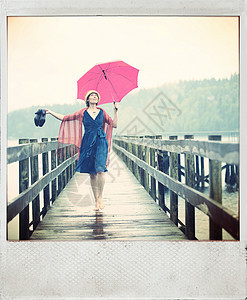 站在码头上带着红色雨伞的女人图片