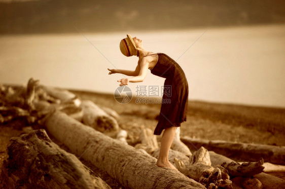 站在浮木上向后伸展的女人图片