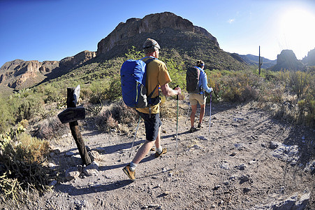 在美国亚利桑那州迷信山徒步旅行的背包情侣背景图片