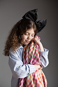 穿着黑蝴蝶结睡衣的年轻女孩拿着舒适的毯子图片