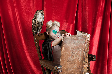 魔术年轻女孩打扮成巫师在读咒语书背景