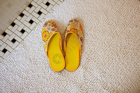 地毯上的一双黄色拖鞋图片