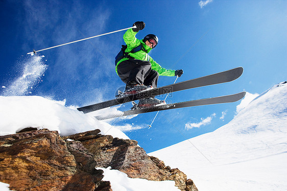 男子滑雪者在山上飞驰而下图片