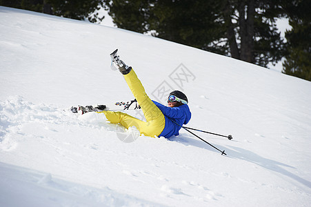 滑雪者摔倒在斜坡上图片