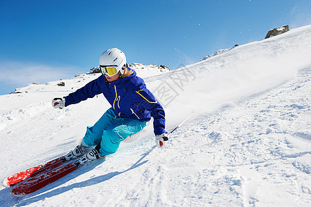 滑雪者下坡滑雪头盔高清图片