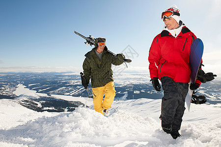 滑雪运动员和滑雪者把装备带到山顶图片