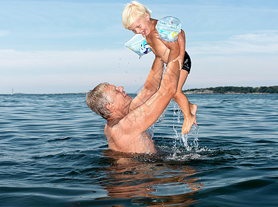 外国留学祖父和男孩在水里玩耍背景