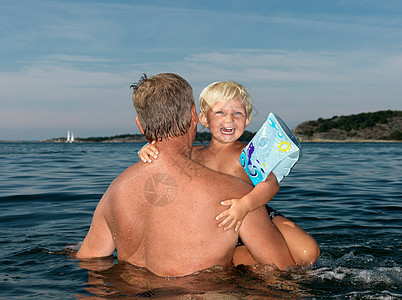 祖父和男孩在水里玩耍图片