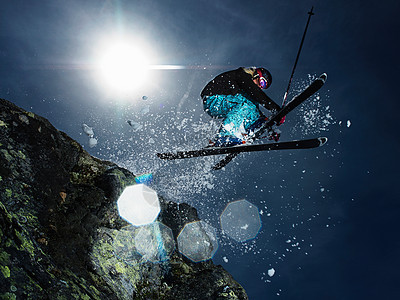 女滑雪者跳过岩石图片