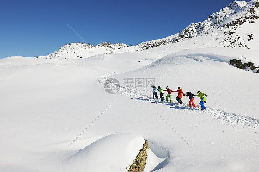 奥地利库赫泰朋友们在雪地里互相拉着上坡图片